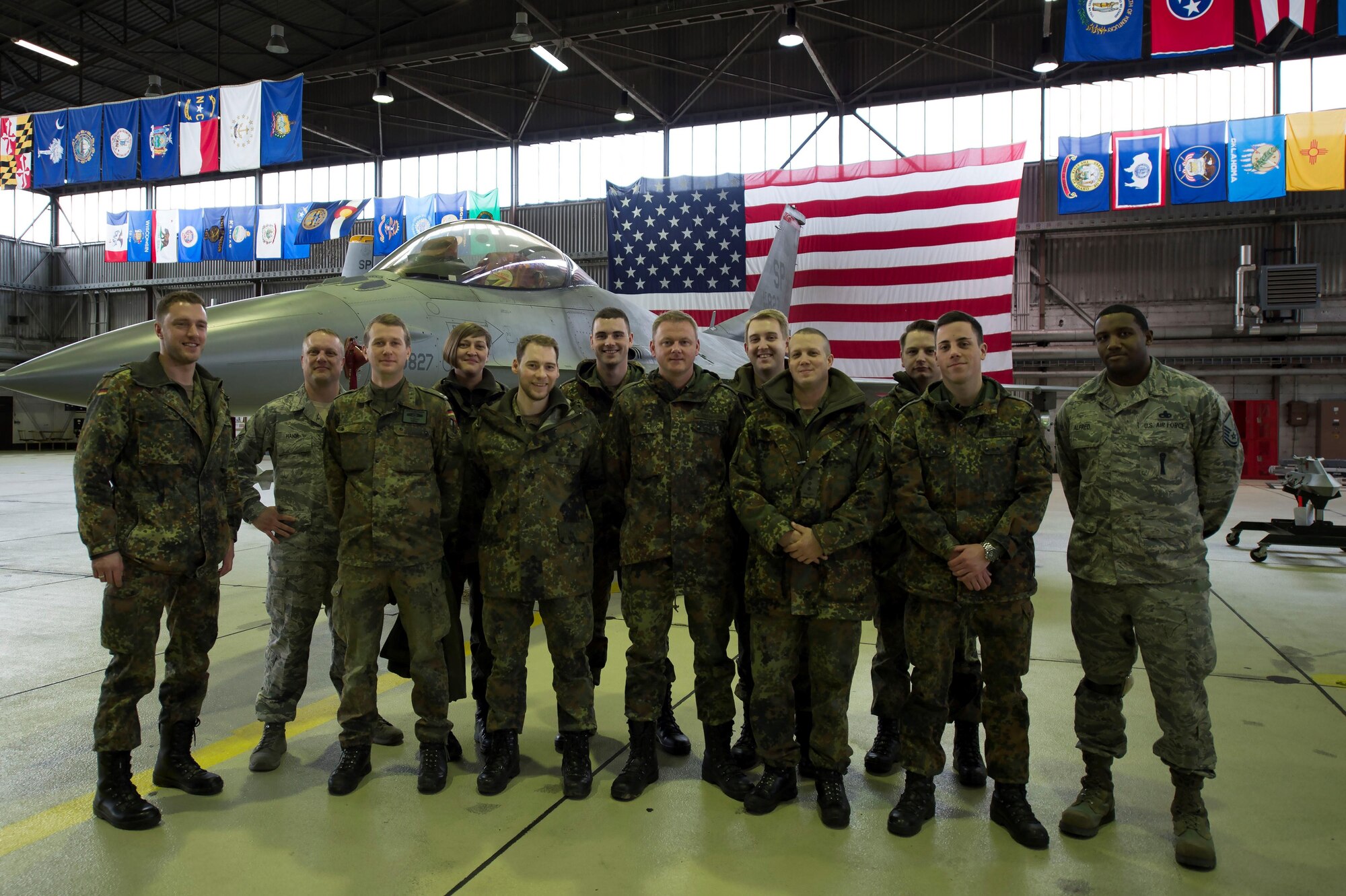 German air force members and U.S. Air Force Airmen pose in front of an F-16 Fighting Falcon in Hangar 1 at Spangdahlem Air Base, Germany, Jan. 31, 2017. The German af visited as part of their Advanced Air Mission Control Course, and the group will also being visited Buechel AB and Polygone Control Center, Bann, Germany, on the tour. (U.S. Air Force photo by Senior Airman Dawn M. Weber)