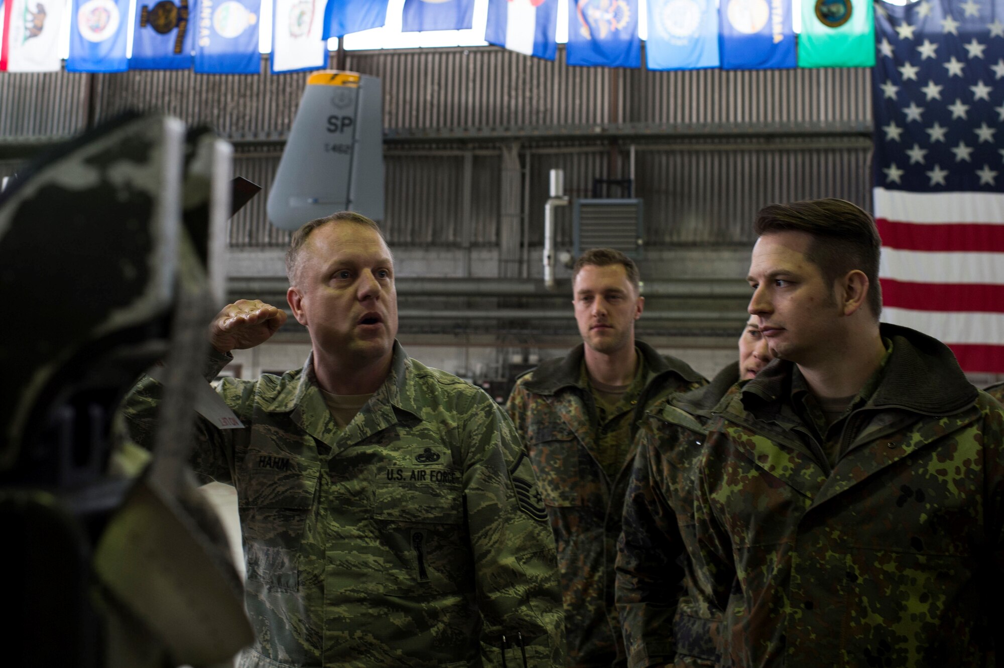 U.S. Air Force Master Sgt. Jonathan Hahm, 52nd Maintenance Group weapons standardization superintendent, briefs members of the German air force about different types of munitions at Spangdahlem Air Base, Germany, Jan. 31, 2017. The German af was given a tour of the base, visiting various facilities such as the fitness center, the tower and Hangar 1 as a way to bolster U.S. and German partnerships. (U.S. Air Force photo by Senior Airman Dawn M. Weber)