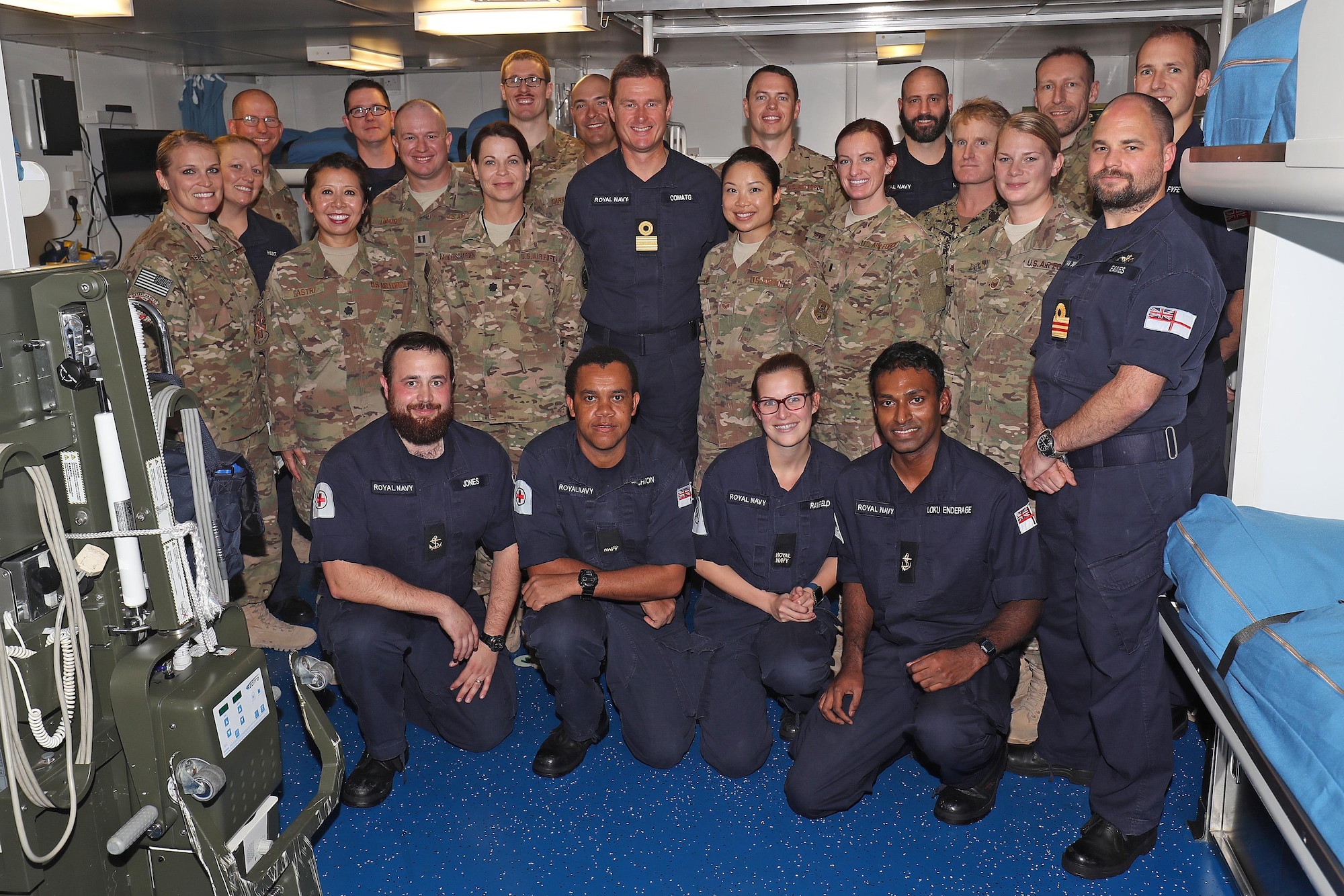 The combined Royal Navy and 379th Expeditionary Medical Operations Squadron mobile field surgical and critical care teams stand together during exercise Azraq Serpent with Commodore Andrew Burns OBE RN, CTF50, Jan. 23, 2017. Members of the Royal Navy and 379th EMDOS came together during coalition exercise Azraq Serpent to simulate receiving casualties on a maritime platform. (Courtesy photo, Royal Navy)