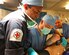 From left, LMT Shavi Locu-Enderage, RN, U.S. Air Force Capt. Carlo Lobato, a 379th Expeditionary Medical Operations Squadron anesthesiologist, and U.S. Air Force Capt. Omar Carrasco, a 379th EMDOS operating room nurse, conduct a full body survey of a Royal marine with simulated injuries onboard the HMS Ocean, Jan. 26, 2017. Members of the Royal navy and 379th EMDOS came together during coalition exercise Azraq Serpent to simulate receiving casualties in a maritime environment. (Courtesy photo/Royal Navy)