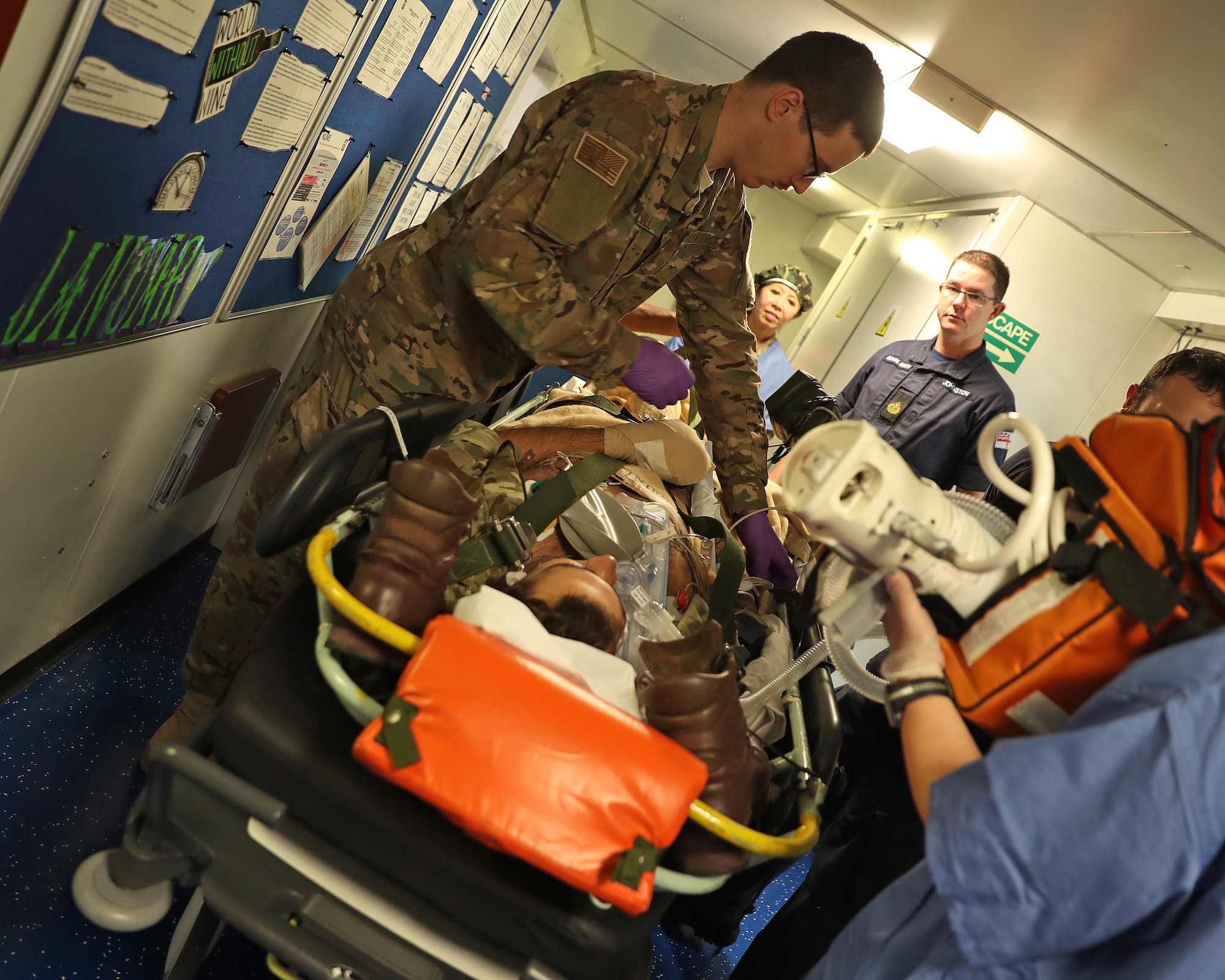 A Royal Marine with simulated injuries is brought into the HMS Ocean medical complex via the elevator, Jan. 26, 2017. Members of the 379th Expeditionary Medical Operations Squadron mobile field surgical and critical care teams integrated with medical specialists in the Royal Navy during exercise Azraq Serpent. (Courtesy photo, Royal Navy)