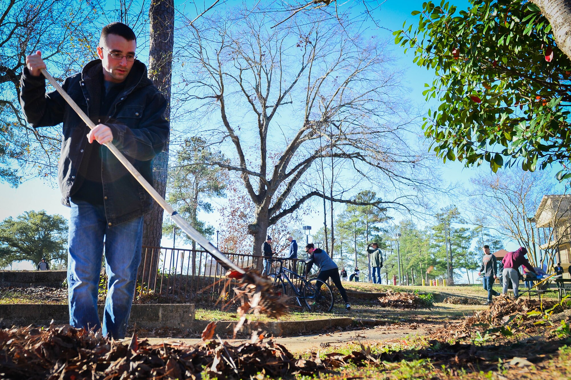 U.S. Air Force Airman 1st Class Zebulun Howard, 20th Operations Support Squadron air traffic control apprentice, rakes leaves during a dorm clean-up at Shaw Air Force Base, S.C., Jan. 28, 2017. During the dorm clean-up Airmen picked weeds, collected trash and power washed buildings. (U.S. Air Force photo by Airman 1st Class Christopher Maldonado)