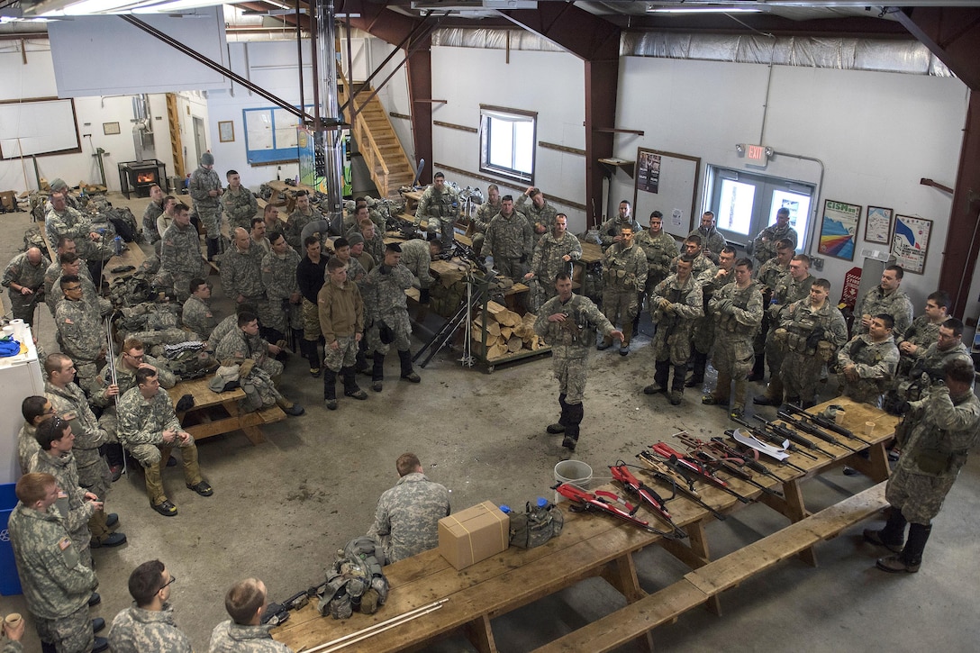 Army National Guard 1st Sgt. Daniel Westover, center right, briefs soldiers on weapons and safety before they participate in training at the Camp Ethan Allen Training Site, Jericho, Vt., Jan. 25, 2017. Westover is assigned to the Vermont National Guard’s Company A, 3rd Battalion, 172nd Infantry Regiment, 86th Infantry Brigade Combat Team (Mountain). Air National Guard photo by Tech. Sgt. Sarah Mattison