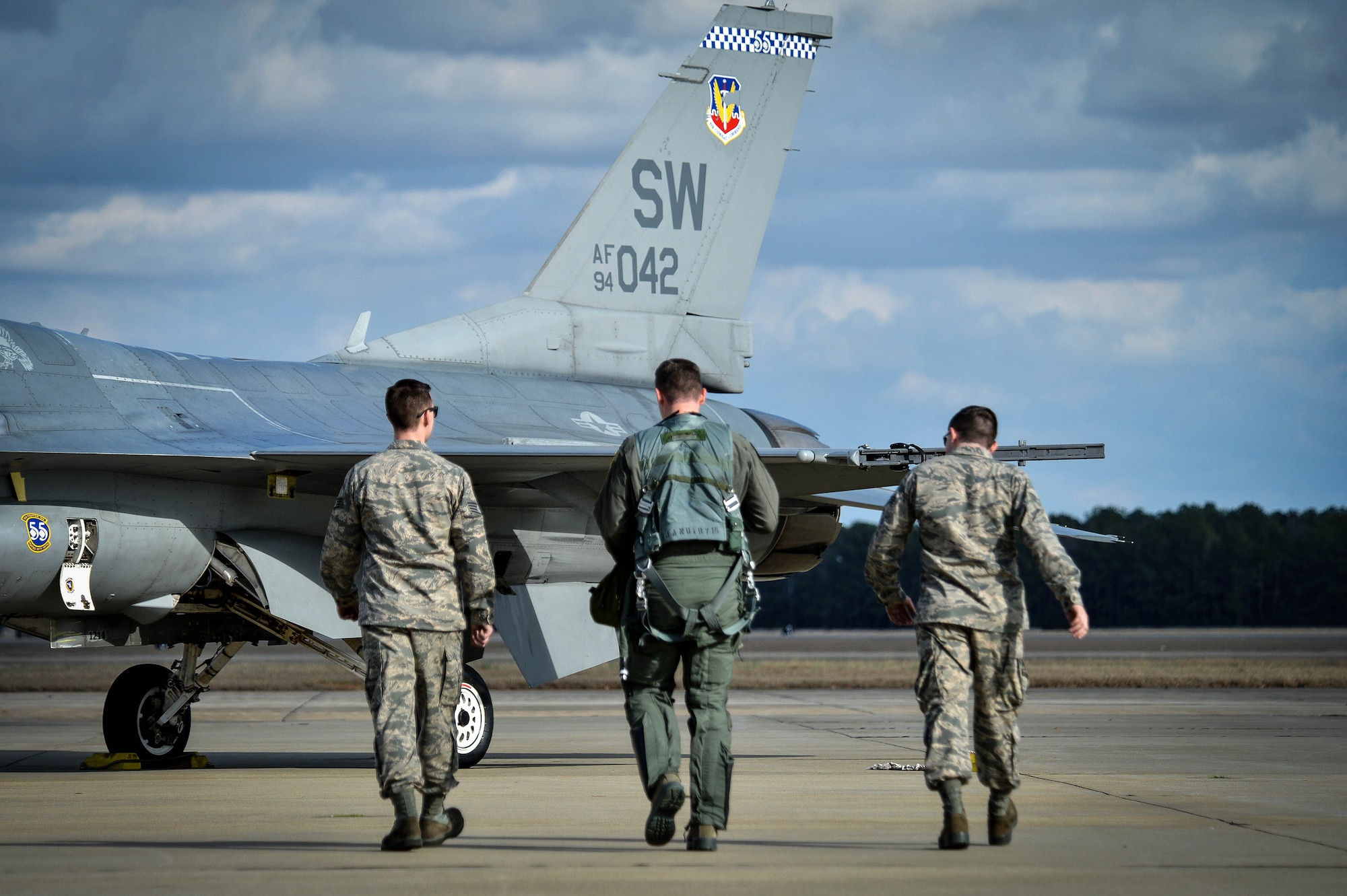(From left) Staff Sgt. Dominic Dizes, F-16 Viper Demonstration Team dedicated crew chief, Capt. John Waters, F-16 Viper Demonstration Team pilot, and Senior Airman Adam Armstrong, F-16 Viper Demonstration Team dedicated crew chief, walk out to their aircraft for a 9th Air Force certification flight at Shaw Air Force Base, S.C., Jan. 20, 2017. The F-16CM Fighting Falcon is a fourth generation fighter aircraft that can withstand nine times the force of gravity, or nine G’s, which exceeds the capability of all other fourth generation fighter aircraft. (U.S. Air Force photo by Senior Airman Michael Cossaboom)