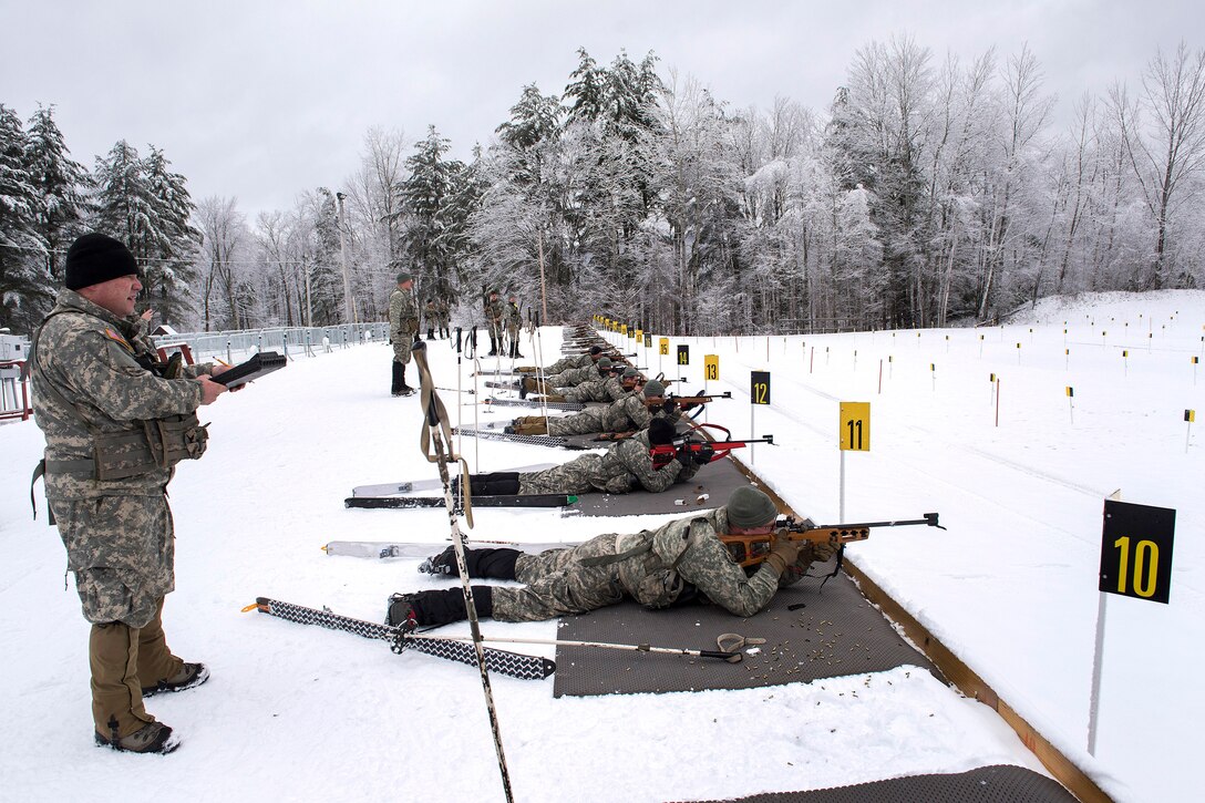 Army National Guard Sgt. 1st Class Will Newell, left, observes soldiers firing their .22-caliber biathlon rifles during marksmanship training at the Camp Ethan Allen Training Site, Jericho, Vt., Jan. 25, 2017. Newell is assigned to the Vermont Army National Guard’s Company A, 3rd Battalion, 172nd Infantry Regiment, 86th Infantry Brigade Combat Team (Mountain). Air National Guard photo by Tech. Sgt. Sarah Mattison