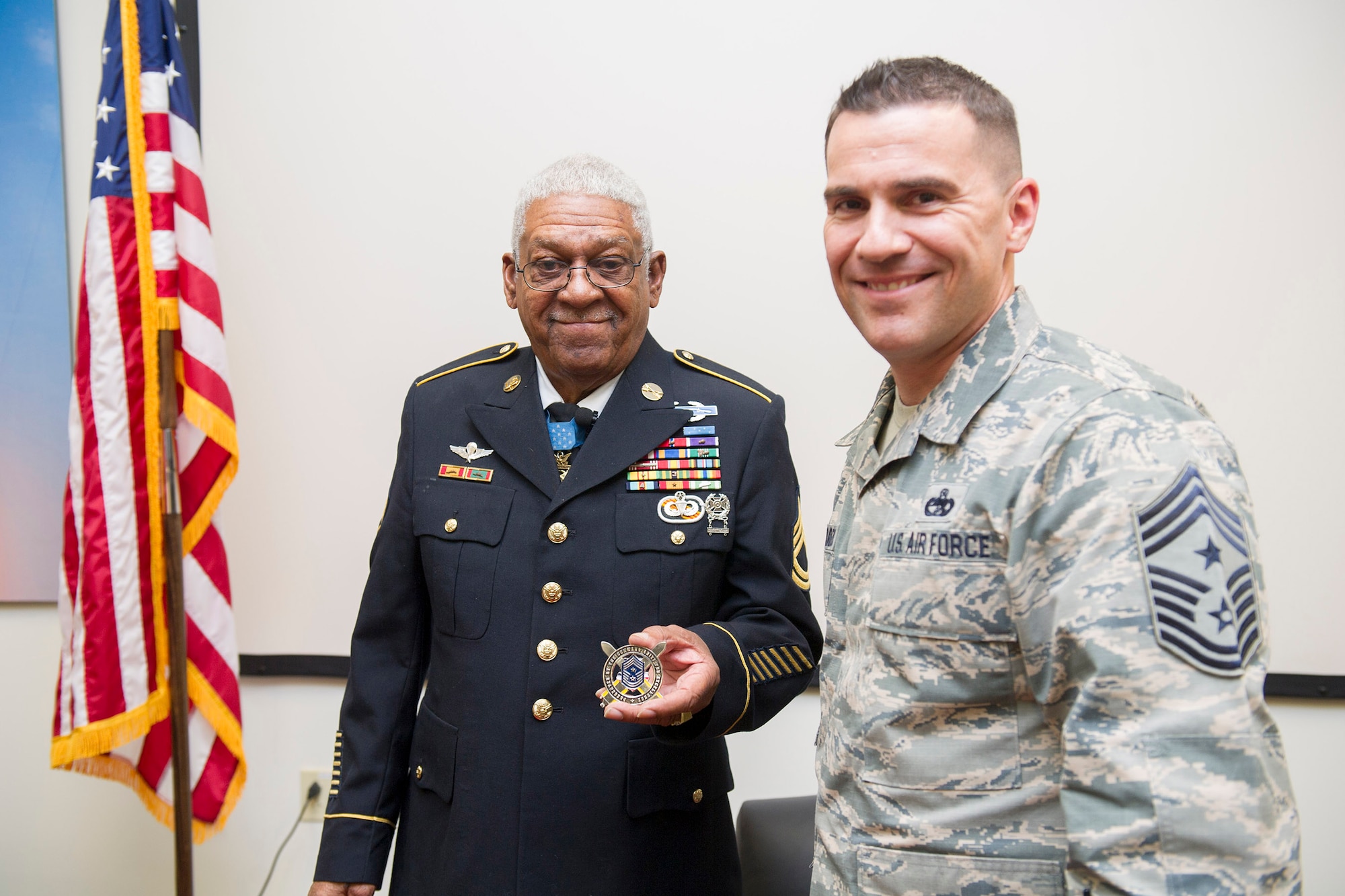 Chief Master Sgt. Jason Lamoureux, 45th Space Wing command chief, coins Medal of Honor recipient retired U.S. Army Sgt. 1st Class Melvin Morris at Patrick AFB, Fla., Jan. 31, 2017. Lamoureux thanked him for his bravery, courage and inspirational message to our service members on the power of the human spirit. (U.S. Air Force photo by Phil Sunkel)