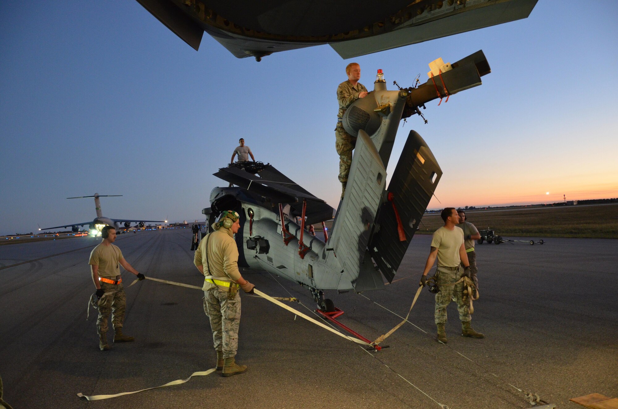 To ensure the flying safety of Air Force choppers used to save lives in combat, maintenance crews from the 920th Rescue Wing swap out an HH-60G Pave Hawk helicopter for reconditioning January 25, 2017. A team of 10 maintainers is necessary to skillfully muscle the metal warrior into the cargo bay however, more often join the unique event for hands-on training and to secure the warrior on a smooth journey over an ocean and a continent to trade places with the combat-weary aircraft. (U.S. Air Force photo/Maj. Cathleen Snow)
