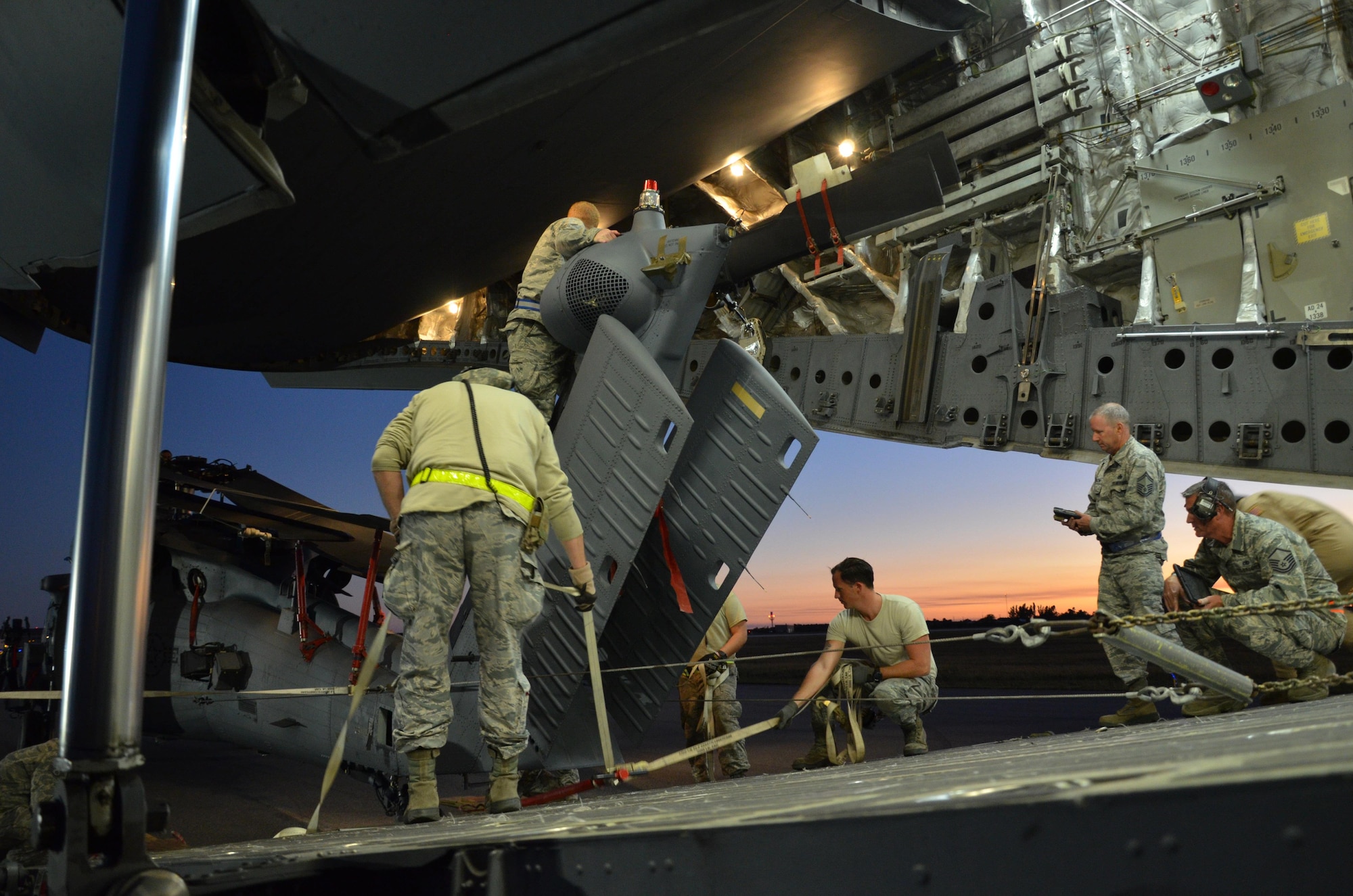 To ensure the flying safety of Air Force choppers used to save lives in combat, maintenance crews from the 920th Rescue Wing swap out an HH-60G Pave Hawk helicopter for reconditioning January 25, 2017. A team of 10 maintainers is necessary to skillfully muscle the metal warrior into the cargo bay however, more often join the unique event for hands-on training and to secure the warrior on a smooth journey over an ocean and a continent to trade places with the combat-weary aircraft. (U.S. Air Force photo/Maj. Cathleen Snow)
