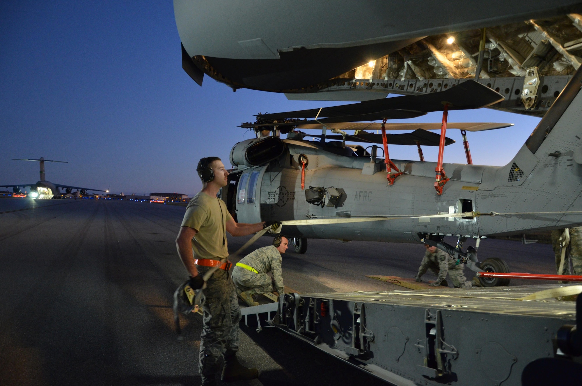 To ensure the flying safety of Air Force choppers used to save lives in combat, maintenance crews from the 920th Rescue Wing swap out an HH-60G Pave Hawk helicopter for reconditioning January 25, 2017. A team of 10 maintainers is necessary to skillfully muscle the metal warrior into the cargo bay however, more often join the unique event for hands-on training and to secure the warrior on a smooth journey over an ocean and a continent to trade places with the combat-weary aircraft. (U.S. Air Force photo/Maj. Cathleen Snow)
