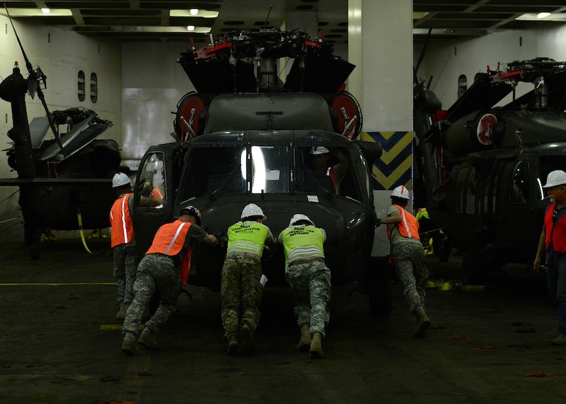 Soldiers from the 841st Transportation Battalion (TB) and the 10th Combat Aviation Brigade  (CAB) move helicopters into position to be strapped down and secured for transport aboard the transport ship ARC Endurance, for shipment to overseas. The 841st TB's mission is to conduct surface deployment and redeployment distribution and water terminal operations in support of the warfighter.