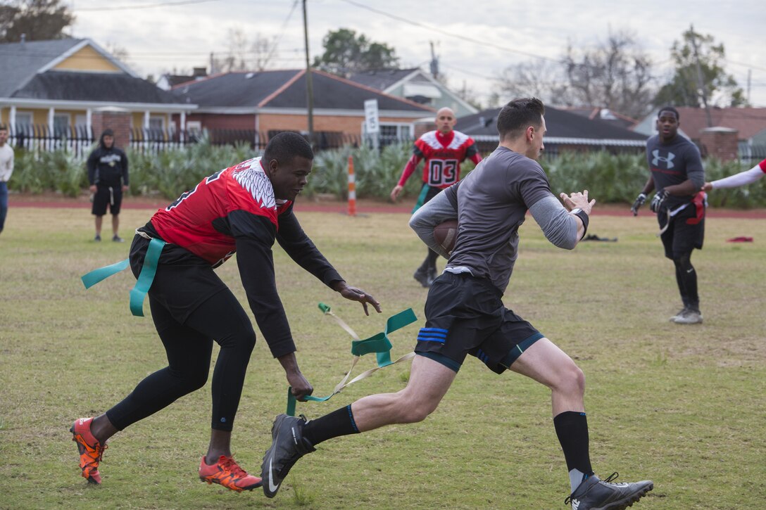 Sgt. Ian M. Lumpkin (right), administration clerk, Installation Personnel Administration Center, Marine Forces Reserve, runs from Sgt. Emmanuel A. Alexisdumas (left), distribution management specialist, MARFORRES, during the Marine Corps Support Facility New Orleans Super Bowl tournament, Jan. 27, 2017. The tournament was held to build camaraderie, unit cohesion and esprit de corps between all departments within MARFORRES Headquarters. (U.S. Marine Corps photo by Lance Cpl. Dallas Johnson/Released)