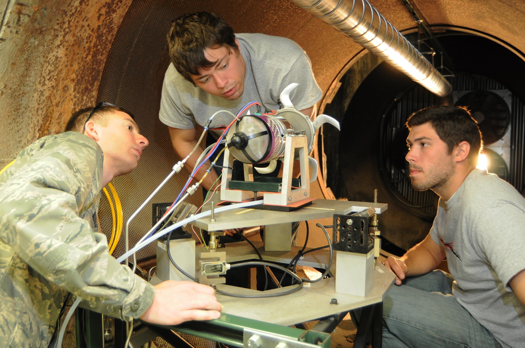 Air Force Capt. Joseph Ausserer assists Aerospace Propulsion Outreach Program students installing their design for testing and evaluation in the Aerospace Systems Directorate’s Small Engine Research Laboratory. The program, referred to as APOP, is a directorate science, technology, engineering, and math (STEM) initiative that funds year-long undergraduate engineer capstone programs across the country that focus on gas turbine engine projects. (Courtesy Photo)