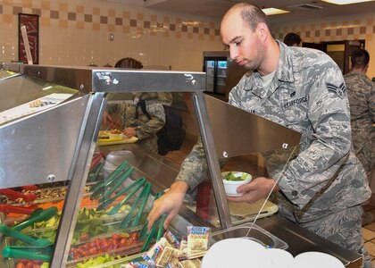 Senior Airman Justin Gram, 437th Maintenance Squadron hydraulics specialist, makes a salad at the Robert D. Gaylor Dining Facility here, Jan. 31, 2017. The dining facility will close for repairs March 1. Airmen on meal cards will receive a basic allowance for subsistence during the 10-month project.
