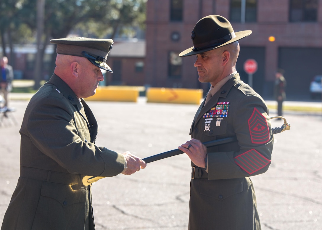 Sgt. Maj. Rafael Rodriguez accepts a noncommissioned officer sword from Brig. Gen. Austin E. Renforth, commanding general of Marine Corps Recruit Parris Island, S.C., on Jan. 13, 2017, during a relief and appointment ceremony for the Marine Corps Recruit Depot Parris Island and Eastern Recruiting Region sergeant major. The passing of the sword symbolizes the transfer of responsibilities and accountability from the outgoing senior-enlisted advisor to the incoming. Sgt. Maj. Angela M. Maness relinquished her post as the Marine Corps Recruit Depot Parris Island and Eastern Recruiting Region sergeant major to Rodriguez, who comes to the depot from Headquarters Regiment, 1st Marine Logistics Group. (Photo by Lance Cpl. Maximiliano Bavastro)