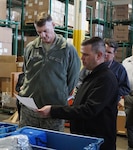 Joseph Sousa, Bulk Distribution Division chief, is showing tDLA director Air Force Lt. Gen. Andy Busch materiel associated with the Wildland Fire Mission during his visit to DLA Distribution San Joaquin. 