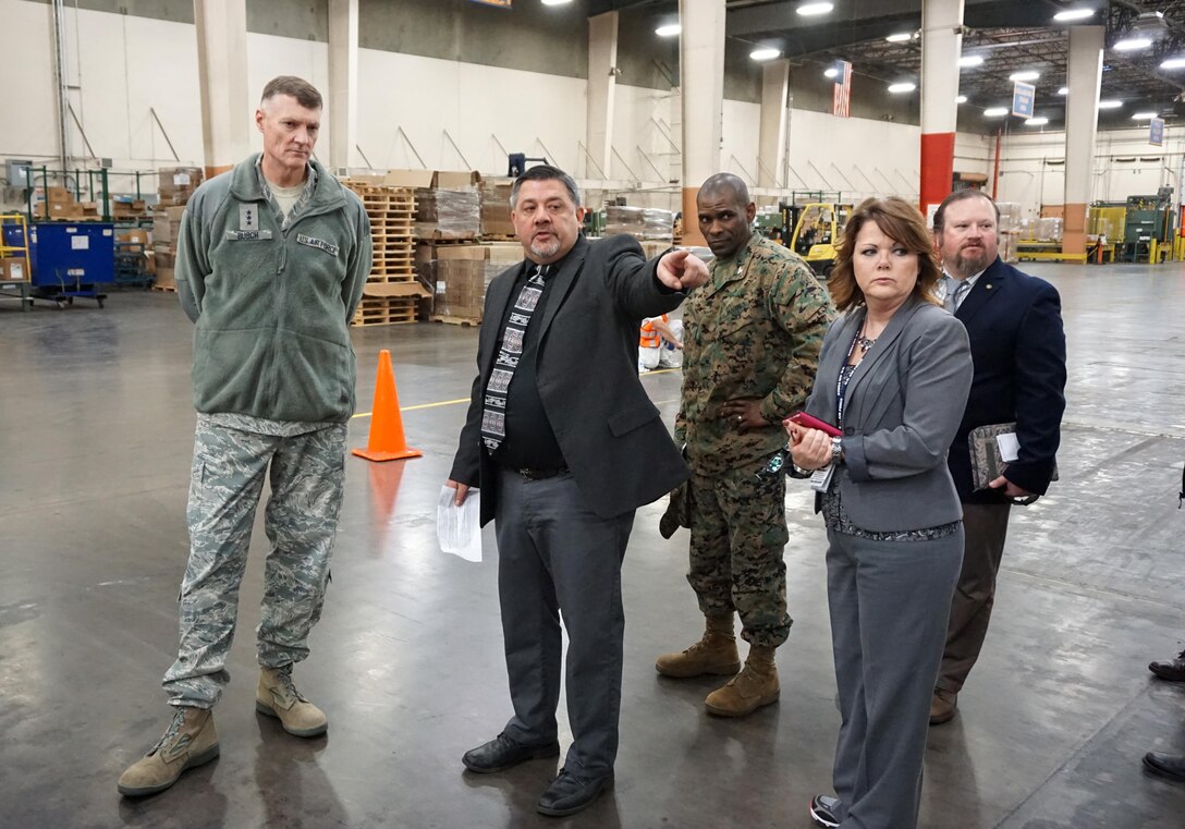 Matthew Messick, Unitized Group Rations Branch chief, shows DLA director Air Force Lt. Gen. Andy Busch the flow of the Unitized Group Rations mission at DLA Distribution San Joaquin.