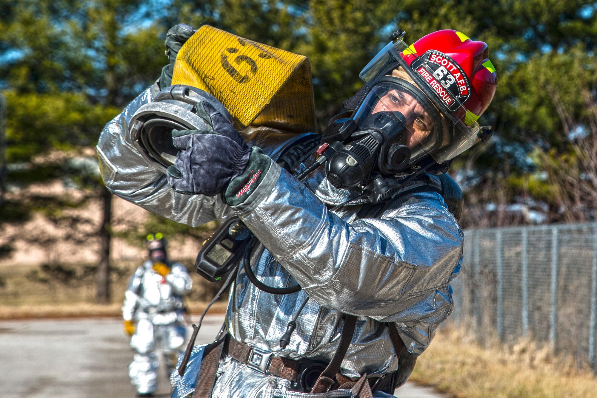 Firefighters with the 375th Civil Engineer Squadron perform drills during a timed test at Scott on Jan. 21. The test explored standards and applied principles of the standards as participants were timed on dragging the hose, putting their gear on and hoisting a hatchet among other smaller drills. Firefighters deal with everything from brush fires to burning rocket fuel and hazardous material fires. Throughout the year the firefighters train on fire suppression, aviation fire suppression, hazardous materials, emergency medical services, technical rescue, fire prevention and public education, as well as adequate standard operating guides, effective program management of additional duties and a comprehensive career training program.