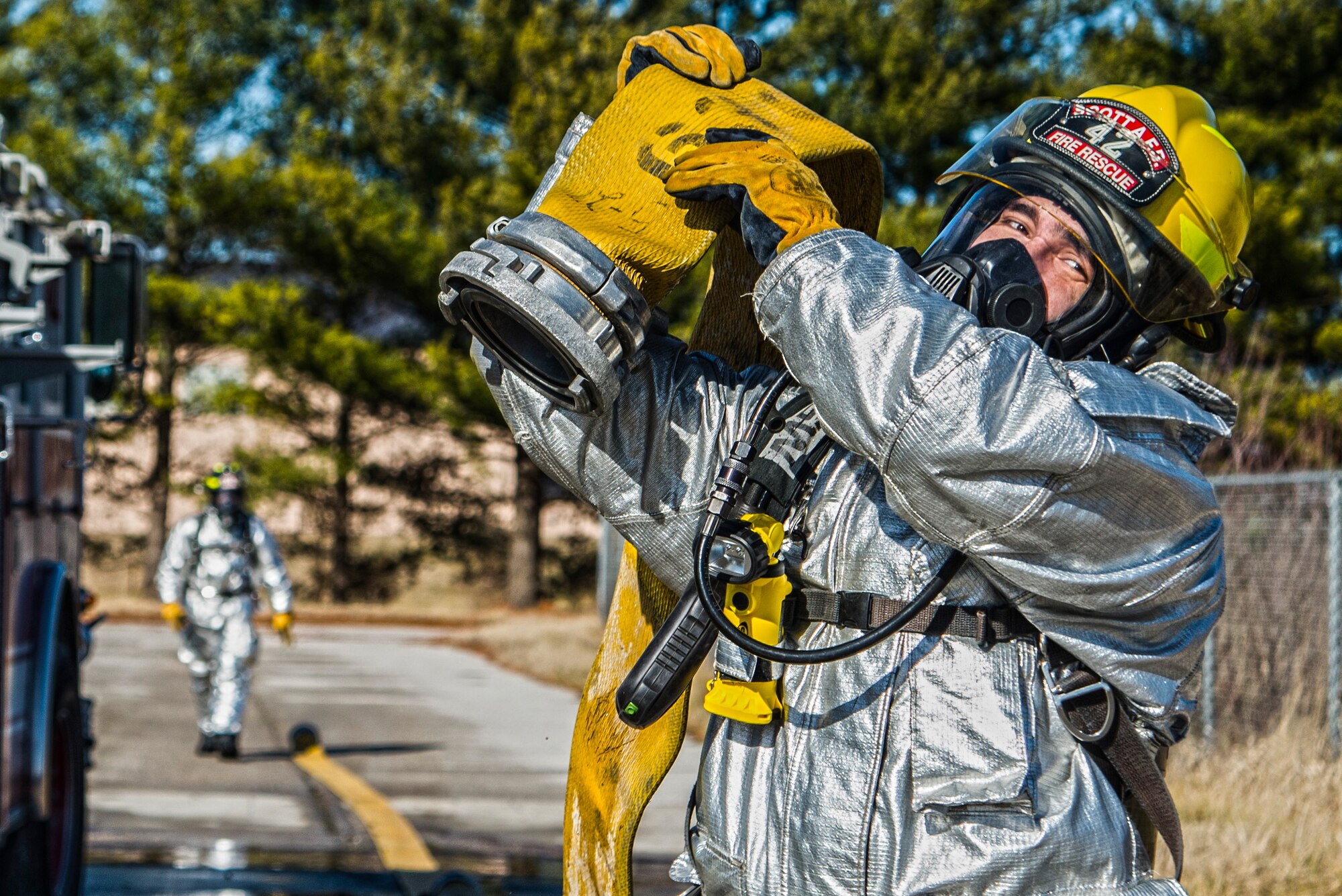 Firefighters with the 375th Civil Engineer Squadron perform drills during a timed test at Scott on Jan. 21. The test explored standards and applied principles of the standards as participants were timed on dragging the hose, putting their gear on and hoisting a hatchet among other smaller drills. Firefighters deal with everything from brush fires to burning rocket fuel and hazardous material fires. Throughout the year the firefighters train on fire suppression, aviation fire suppression, hazardous materials, emergency medical services, technical rescue, fire prevention and public education, as well as adequate standard operating guides, effective program management of additional duties and a comprehensive career training program.