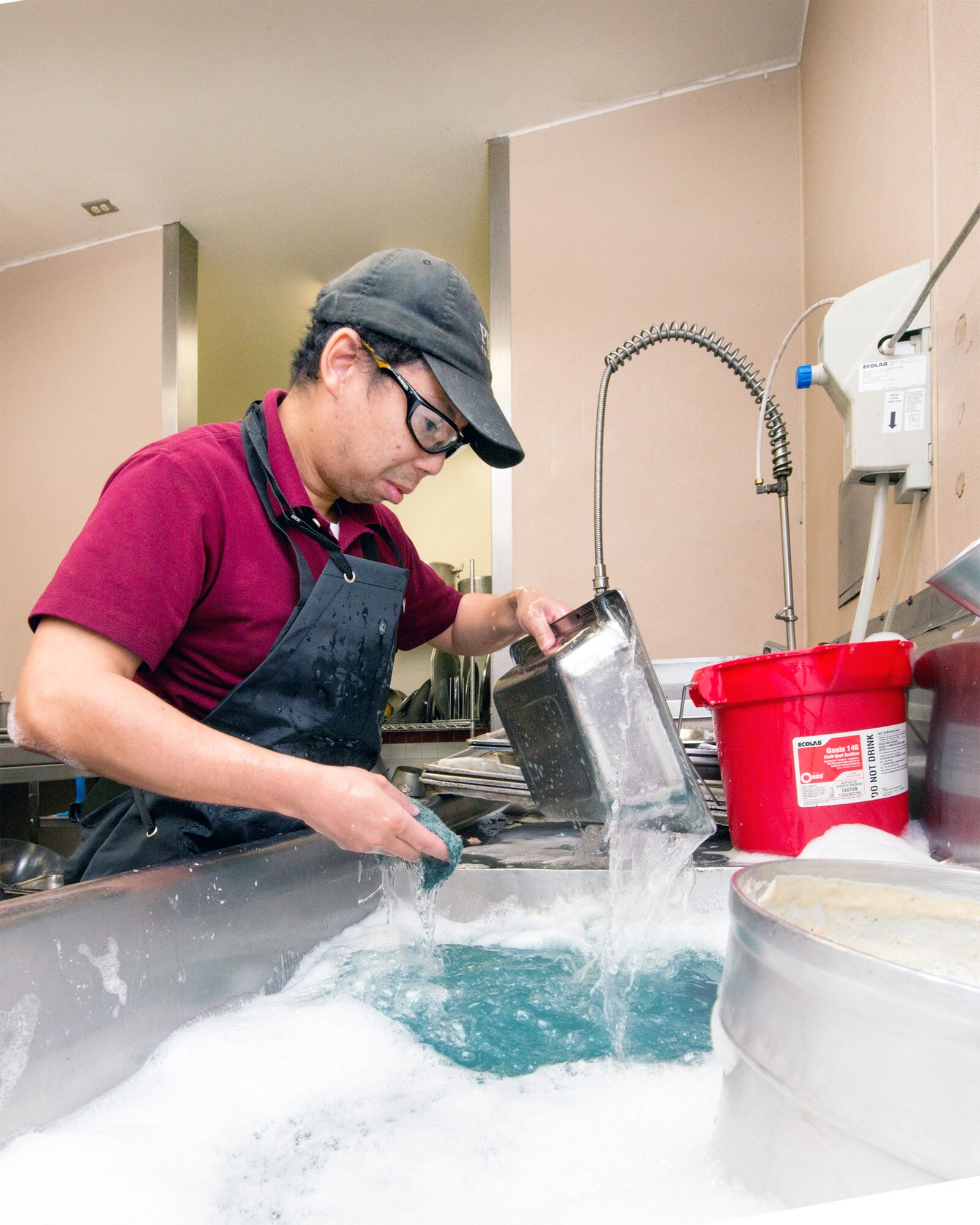 Quincey Yee, of Pride Industries washes pots at the Sierra Inn Dining Facility at Travis Air Force Base, Calif., Jan. 25, 2017. The dining facility was named Air Mobility Command's best and will now compete at the Air Force level for the John L. Hennessy Trophy, which recognizes excellence in food service. (U.S. Air Force photo/Louis Briscese)