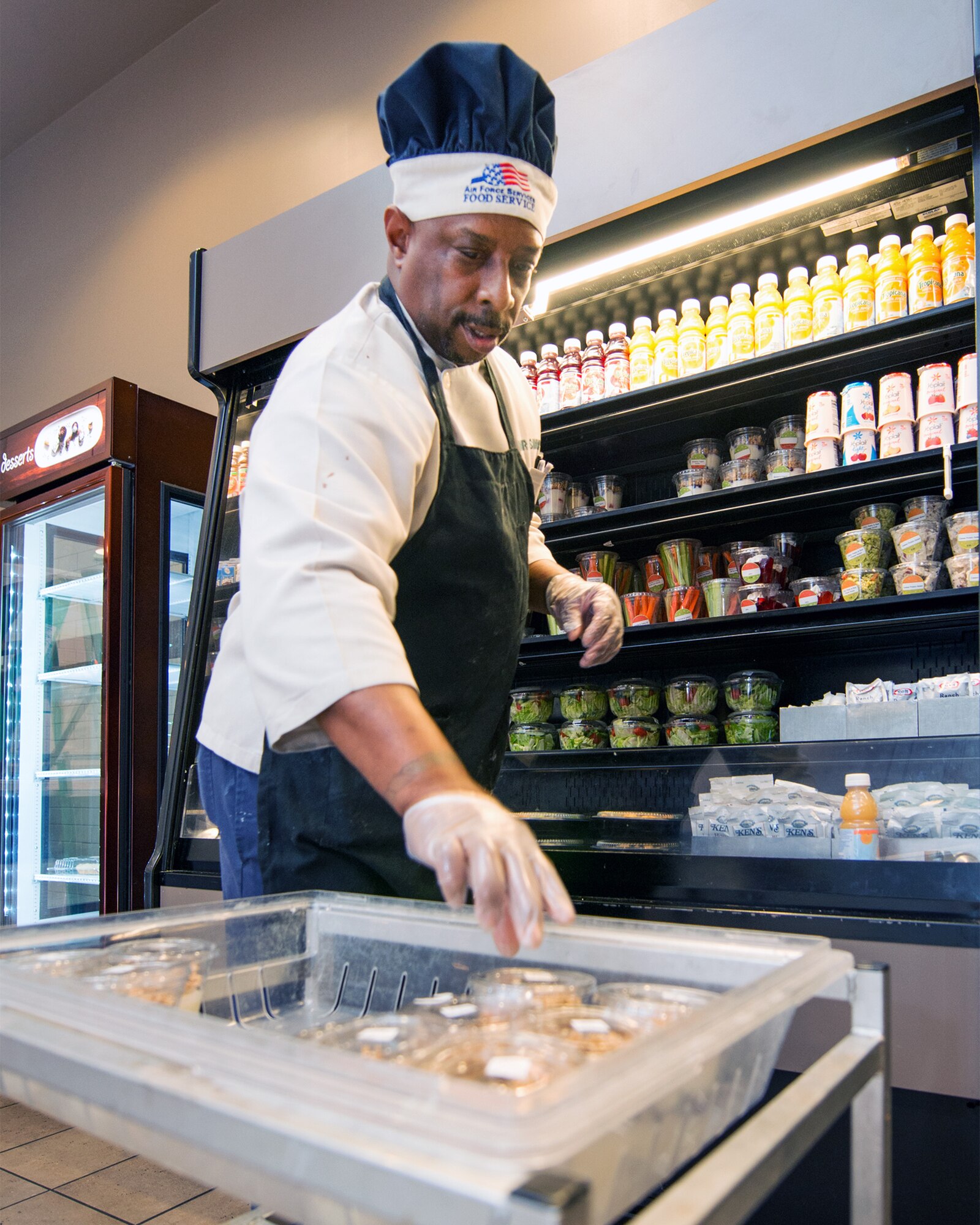Sam Simmons, 60th Force Support Squadron, restocks food at the Sierra Inn Dining Facility at Travis Air Force Base, Calif., Jan. 25, 2017. The dining facility was named Air Mobility Command's best and will now compete at the Air Force level for the John L. Hennessy Trophy, which recognizes excellence in food service. (U.S. Air Force photo/Louis Briscese)