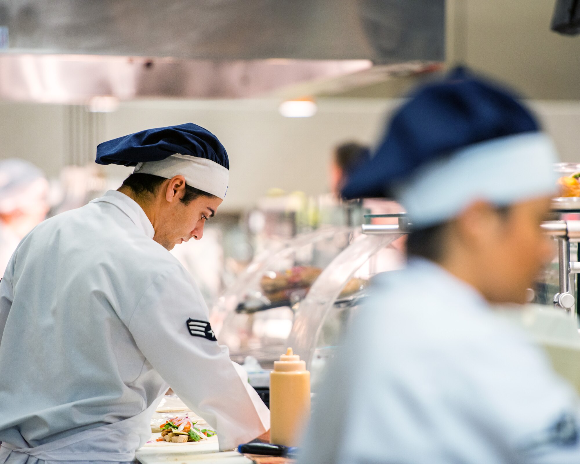 U.S Air Force Senior Airman Jeremy King, 60th Force Support Squadron, prepares food during lunch at the Sierra Inn Dining Facility at Travis Air Force Base, Calif., Jan. 25, 2017. The dining facility was named Air Mobility Command's best and will now compete at the Air Force level for the John L. Hennessy Trophy, which recognizes excellence in food service. (U.S. Air Force photo/Louis Briscese)