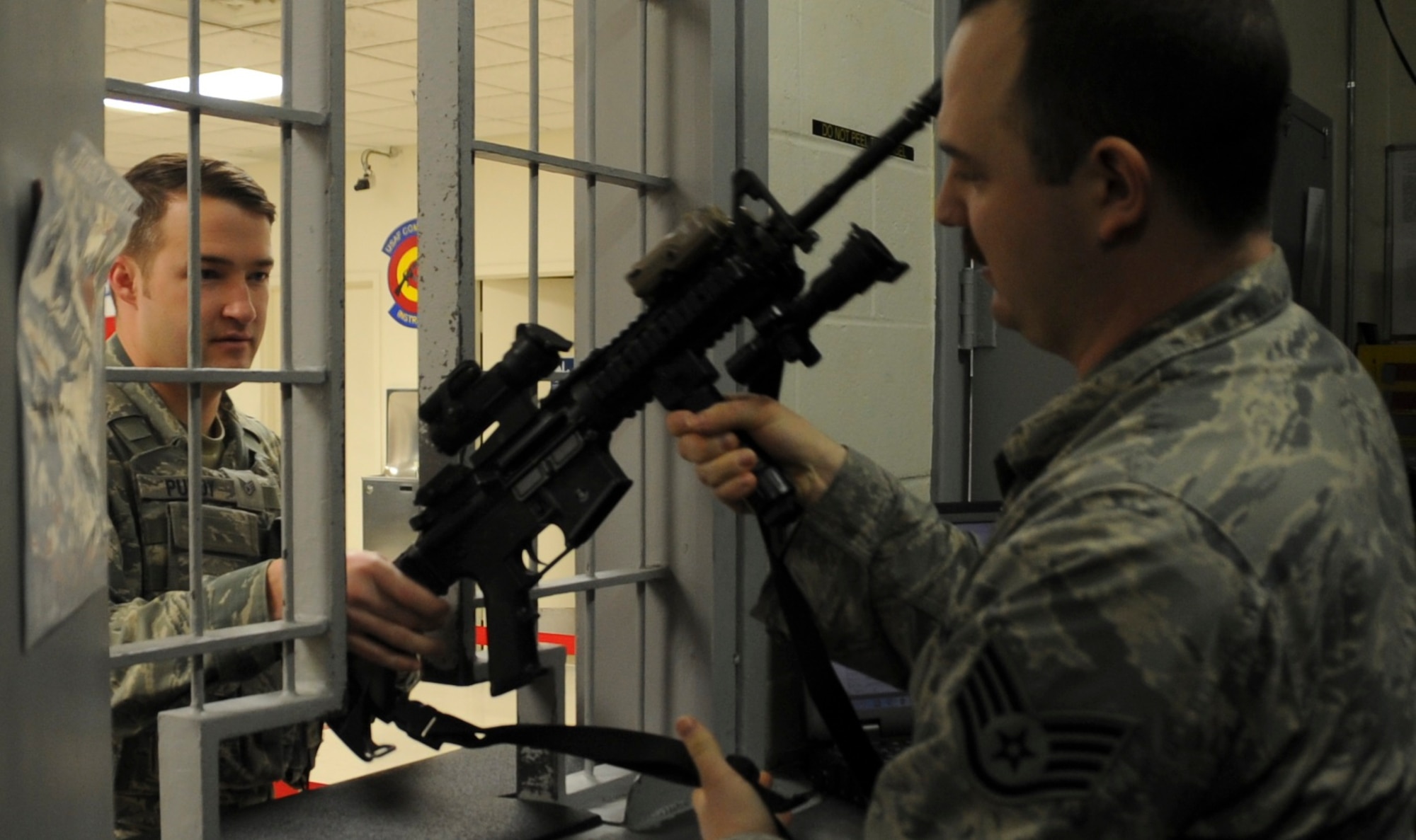 Staff Sgt. Kit Purty, Security Forces Squadron defender receives am M-4 carbine rifle from Staff Sgt. Jonathan Ginn, 92nd SFS armorer during a shift change arming at the armory at Fairchild Air Force Base, Washington, January 24, 2017.  Weapons in the armory are now checked out using an electronic tracking system that may save the 92nd SFS 750 man hours per year. (U.S. Air Force photo/ Airman 1st Class Sean Campbell)