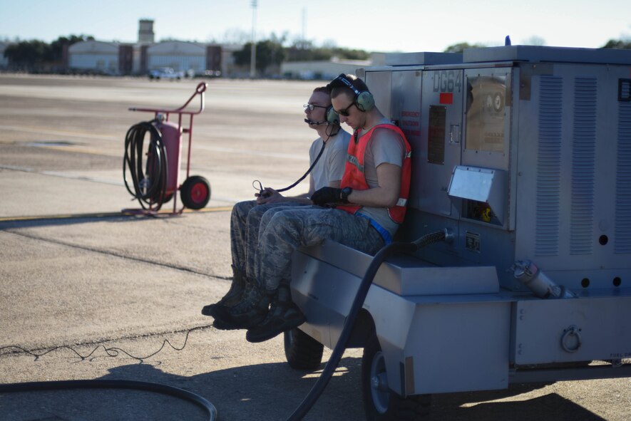 Senior Airman Calvin Kunkel and Airman 1st Class Terell Holmstrom, 2nd Aircraft Maintenance Squadron crew chiefs, sit on a generator cart during a quick break at Barksdale Air Force Base, La., Jan. 30, 2017. The generator cart provides electric power to the B-52 Stratofortress. (U.S. Air Force photo/Airman 1st Class Stuart Bright)