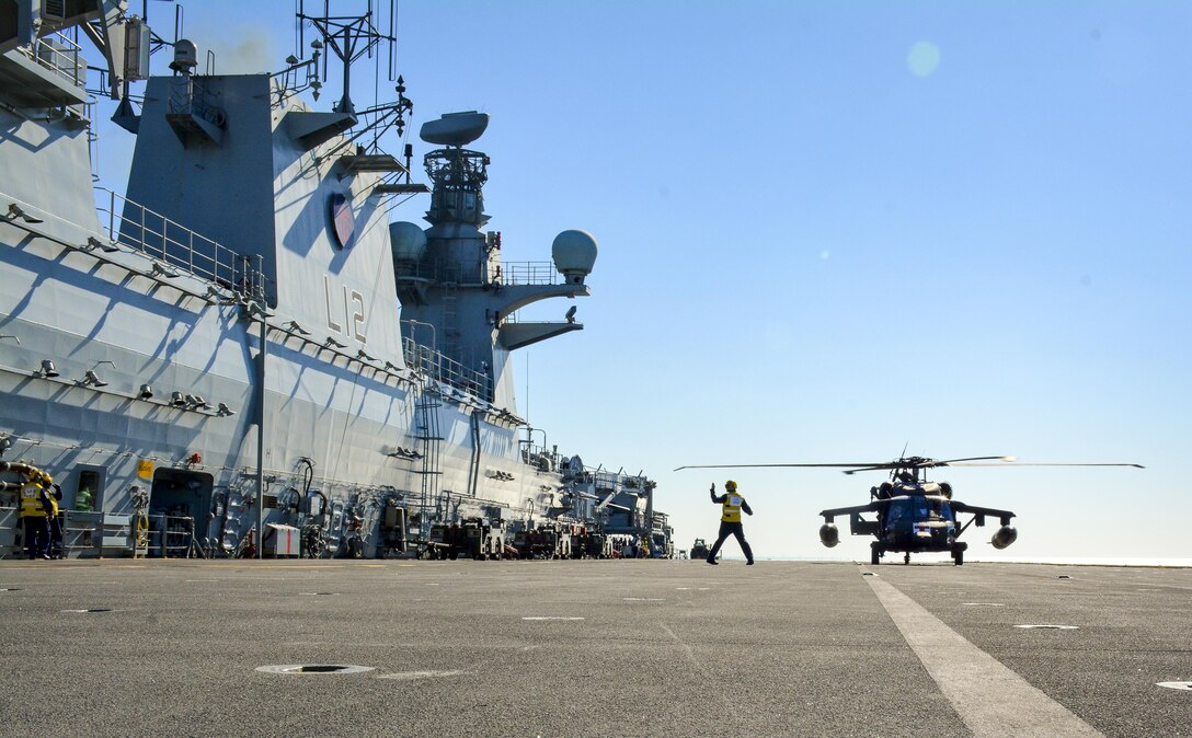 Kuwait- Pilots of a UH-60 Black Hawk from Charlie Company, 1st BN, 111th AVN REGT, take their landing guidance from the Leading Aircraftman Cook with the Royal Navy's HMS Ocean, during the deck landing qualification joint training mission in the Arabian Gulf, Dec. 11, 2012.
(Photo by Army Sgt. 1st Class Suzanne Ringle/Released)
