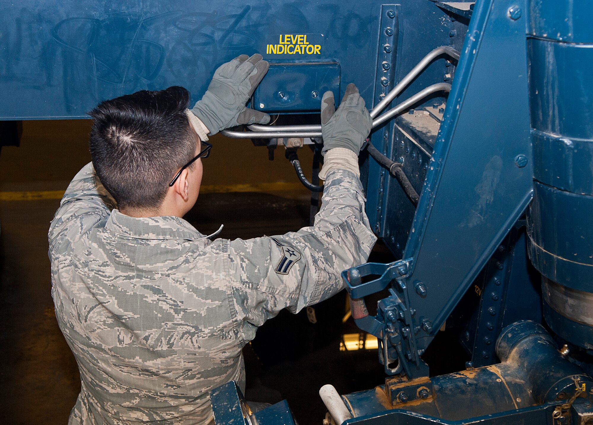 Airman 1st Class Antonio Torres, 91st Missile Maintenance Squadron missile handling team technician, re-installs a level indicator cover at Minot Air Force Base, N.D., Jan. 19, 2017. The level indicator allows the MHT to ensure the transporter erector is properly level while in use. (U.S. Air Force photo/Airman 1st Class Jonathan McElderry)