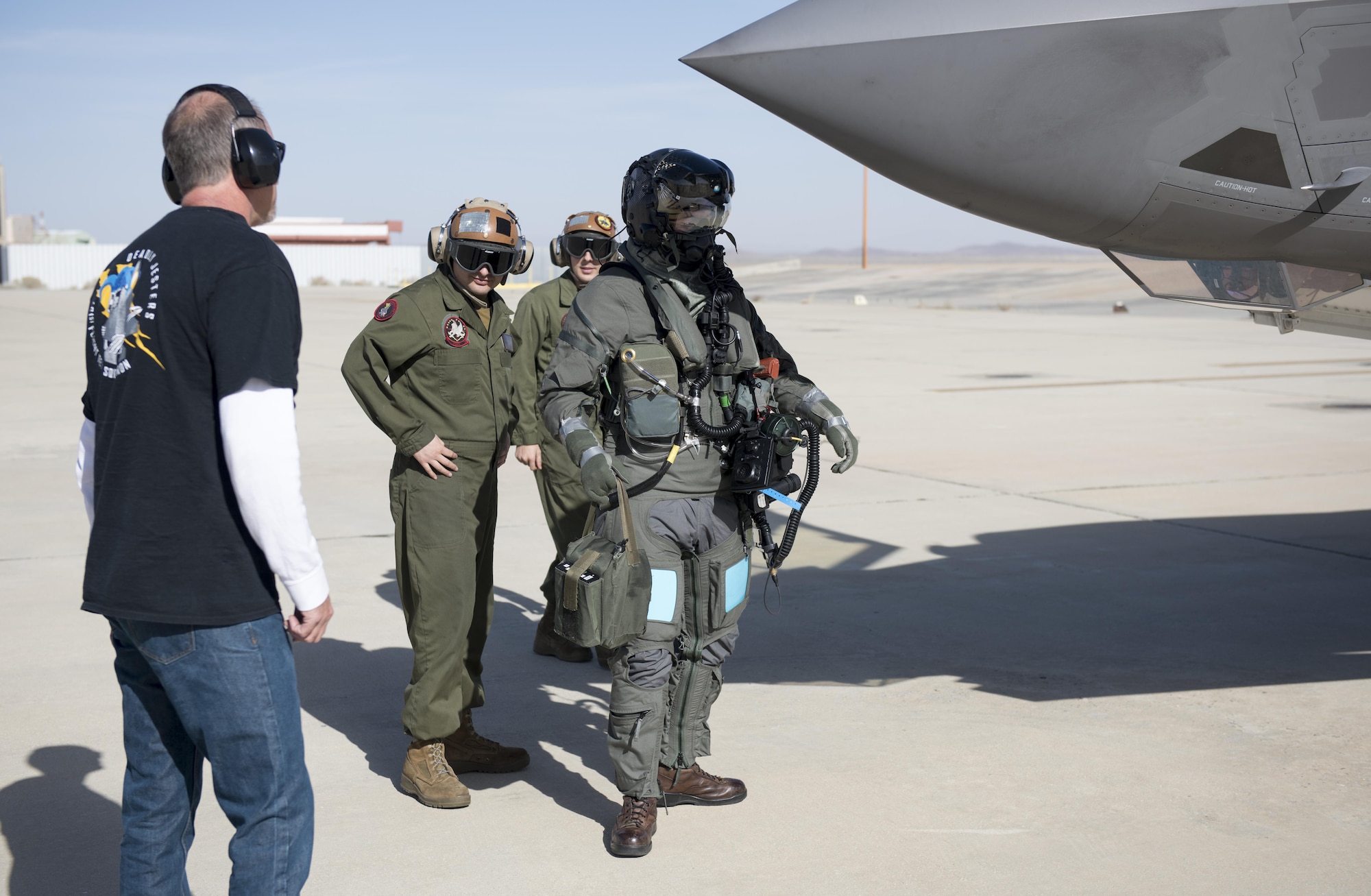 Marine Corps Maj. Aaron Frey (center) prepares to board a Marine F-35B Joint Strike Fighter in a chemical/biological ensemble. All components of the CB ensemble are in addition to the pilot’s sleeved flight jacket and G suit. (U.S. Air Force photo by Brad White)