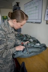 Tech. Sgt. Rachel R. Atchley, 374th Operations Support Squadron Aircrew Flight Equipment Flight quality assurance program manager, performs a final equipment check on a back automatic parachute before it is placed for use on a C-130H Hercules Jan. 20, 2017 at Yokota Air Base, Japan. The AFE flight is responsible for the repair, packing, and all-around maintenance of parachutes used by aircrew and survival, evasion, resistance and escape specialists. (U.S. Air Force photo by Airman 1st Class Donald Hudson)