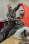 Airman 1st Class Brent T. Spencer, 374th Operations Support Squadron Aircrew Flight Equipment Flight apprentice, pre-packs a parachute canopy Jan. 31, 2017, at Yokota Air Base, Japan. The AFE flight is responsible for the repair, packing, and all-around maintenance of parachutes used by aircrew and survival, evasion, resistance and escape specialists. (U.S. Air Force photo by Airman 1st Class Donald Hudson)