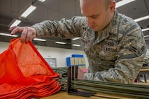 Airman 1st Class Brent T. Spencer, 374th Operations Support Squadron Aircrew Flight Equipment Flight apprentice, checks the air channel of a parachute canopy Jan. 31, 2017 at Yokota Air Base, Japan. The AFE flight is responsible for the repair, packing, and all-around maintenance of parachutes used by aircrew and survival, evasion, resistance and escape specialists. (U.S. Air Force photo by Airman 1st Class Donald Hudson)