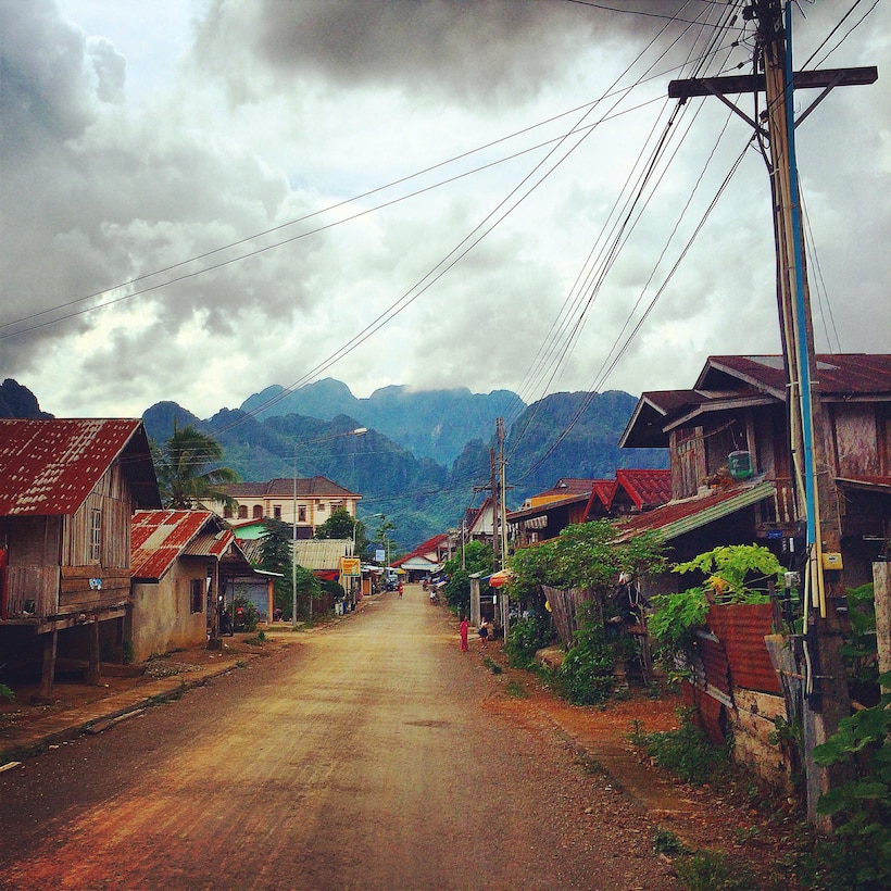 This photo sets the relatively well-developed town of Vang Vieng, with its roads and power lines, into the contextual reality of Lao PDR's mountainous terrain.  The Lao population benefits from higher road access and rural electrification rates than other countries at the same per capita income level.