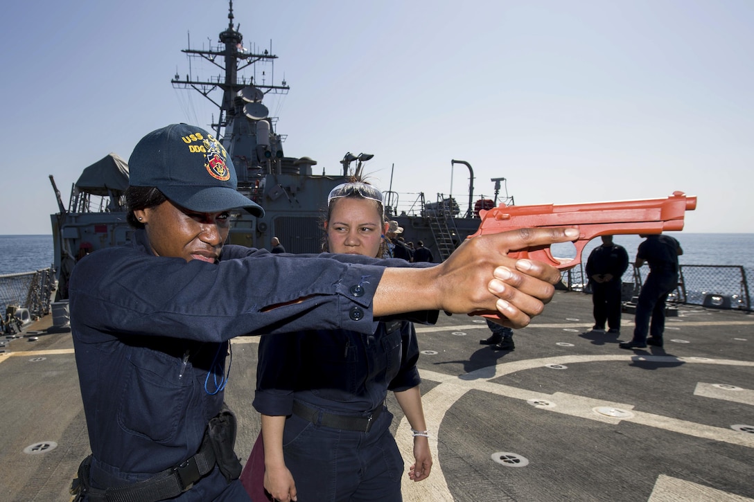 Navy Seaman Raquel Tonge, left, receives training from Petty Officer 2nd Class Diana Fischer during a training course on armed sentry and security reaction aboard the USS Cole in the Gulf of Oman, Jan. 30, 2017. Tonge is a gas turbine systems mechanic fireman and Fischer is a gunner's mate. The ship is supporting maritime security operations and theater security cooperation efforts in the U.S. 5th Fleet area of operations. Navy Petty Officer 3rd Class Brianna K. Green