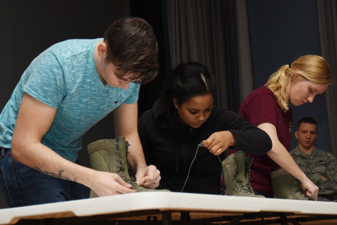 Off-duty volunteers lace up boots during a driving under the influence awareness seminar at Royal Air Force Lakenheath, England, Jan. 27. The volunteers had each consumed different amounts of alcohol prior to the demonstration and were asked to complete tasks aimed to demonstrate how alcohol consumption affects fine motor skills. (U.S. Air Force photo/Airman 1st Class Abby L. Finkel)