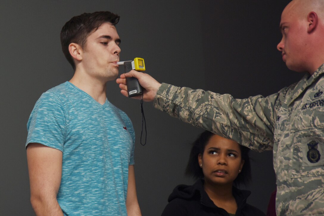 An off-duty volunteer takes a breathalyzer test during a driving under the influence awareness seminar at Royal Air Force Lakenheath, England, Jan. 27. A vehicle operator with a blood alcohol content of 0.08 grams of alcohol per 100 milliliters of blood is legally intoxicated under the Uniform Code of Military Justice. (U.S. Air Force photo/Airman 1st Class Abby L. Finkel)