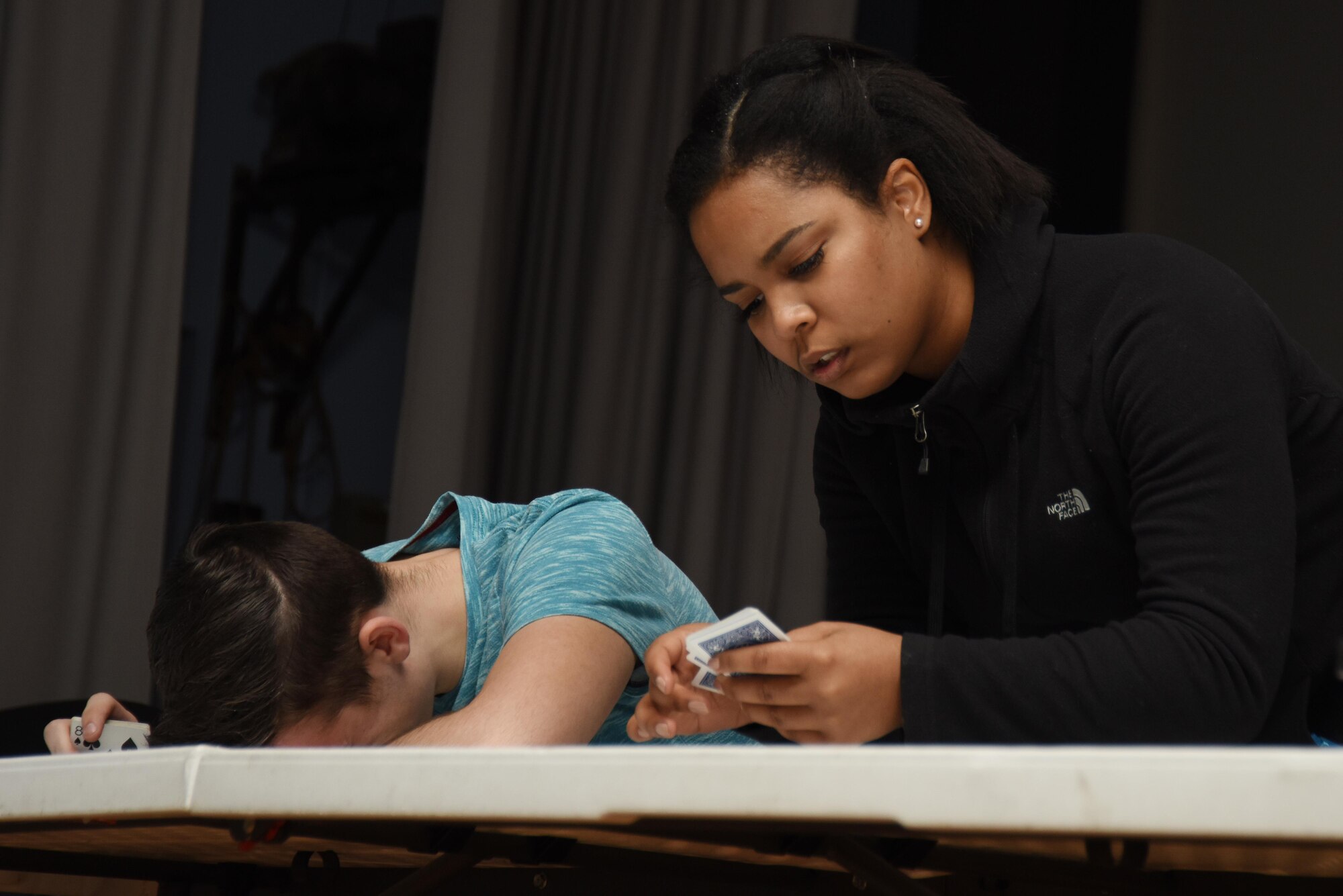 Two off-duty volunteers look for specific cards during a driving under the influence awareness seminar at Royal Air Force Lakenheath, England, Jan. 27. The volunteers had to complete several tasks that tested their fine motor skills and ability to follow simple directions. (U.S. Air Force photo/Airman 1st Class Abby L. Finkel)