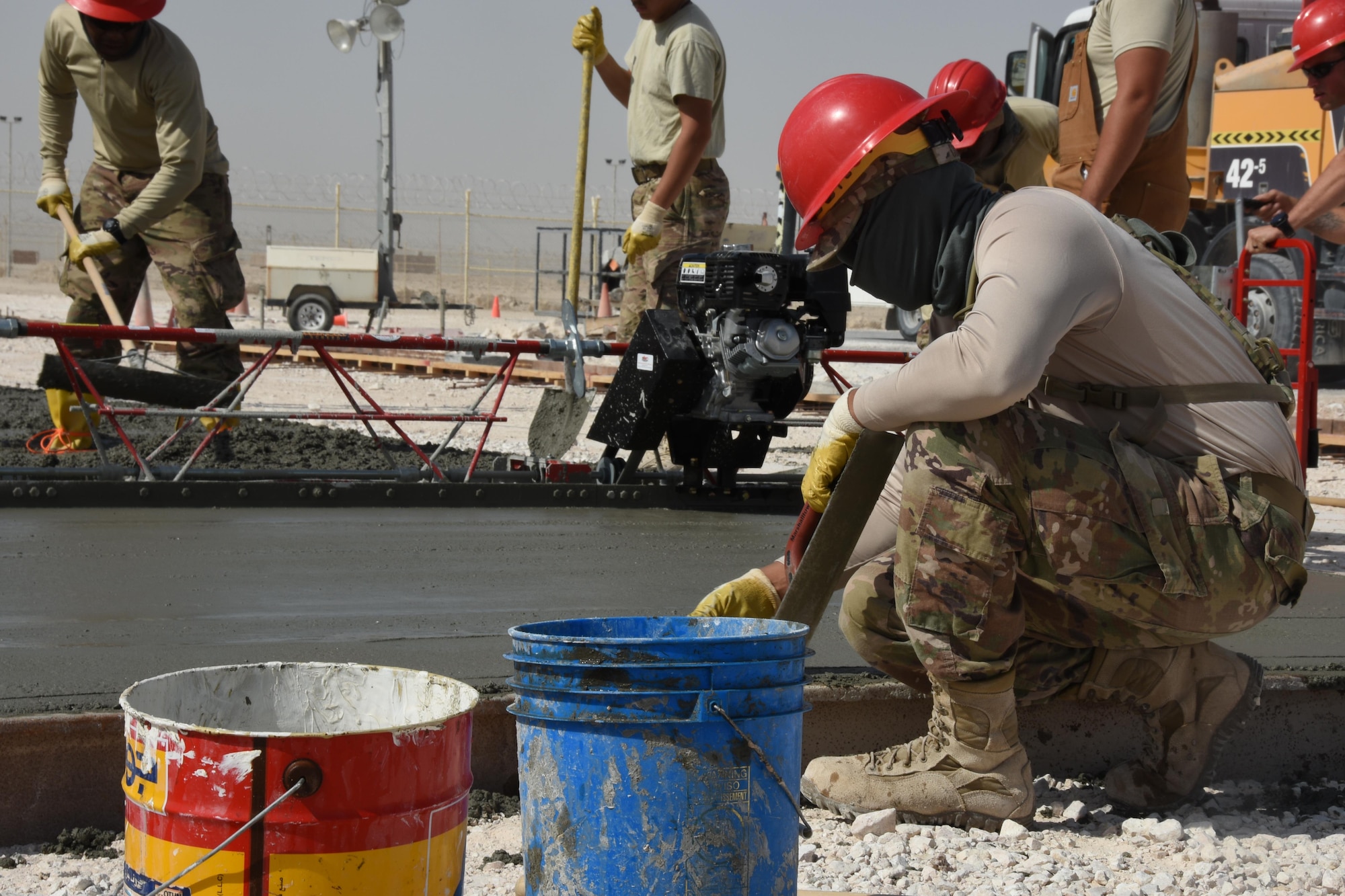 An Airman with the 557th Expeditionary RED HORSE Squadron smooths concrete during construction at the close air support ramp, Al Udeid Air Base, Qatar, Jan. 31, 2017. The 557th ERHS Airmen are laying the foundation for an aircraft maintenance workshop and administration building.  (U.S. Air Force photo by Senior Airman Cynthia A. Innocenti)