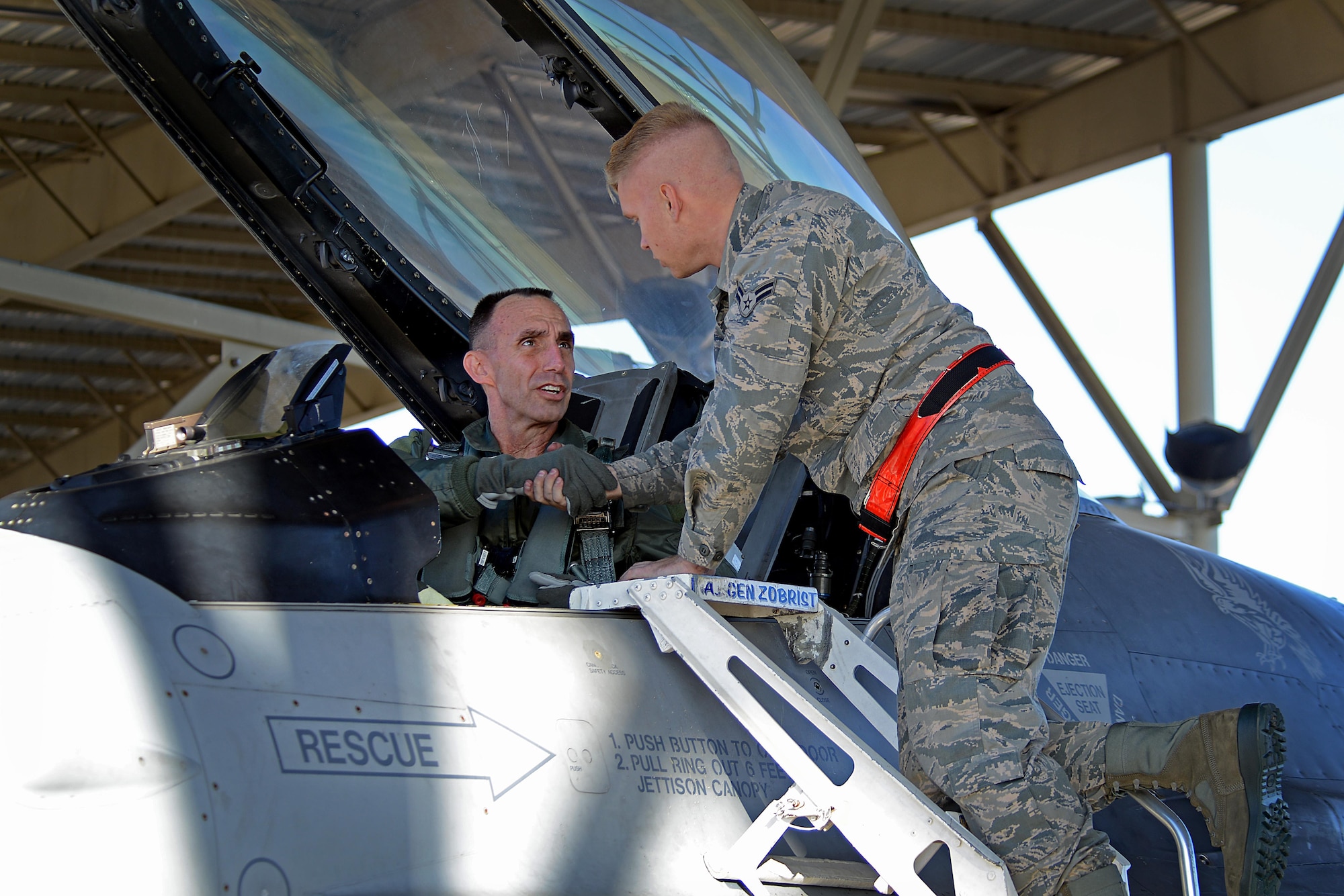 U.S. Air Force Maj. Gen. Scott Zobrist, 9th Air Force commander, shakes hands with Airman 1st Class Michael Gradecki, a 20th Aircraft Maintenance Squadron crew chief, as he prepares for takeoff at Shaw Air Force Base, S.C., Dec. 1, 2016. Zobrist assumed command of 9th Air Force in May 2016 and has held staff positions at the Air Staff, Air Combat Command and U.S. Forces Japan. (U.S. Air Force photo by Airman 1st Class Kelsey Tucker)