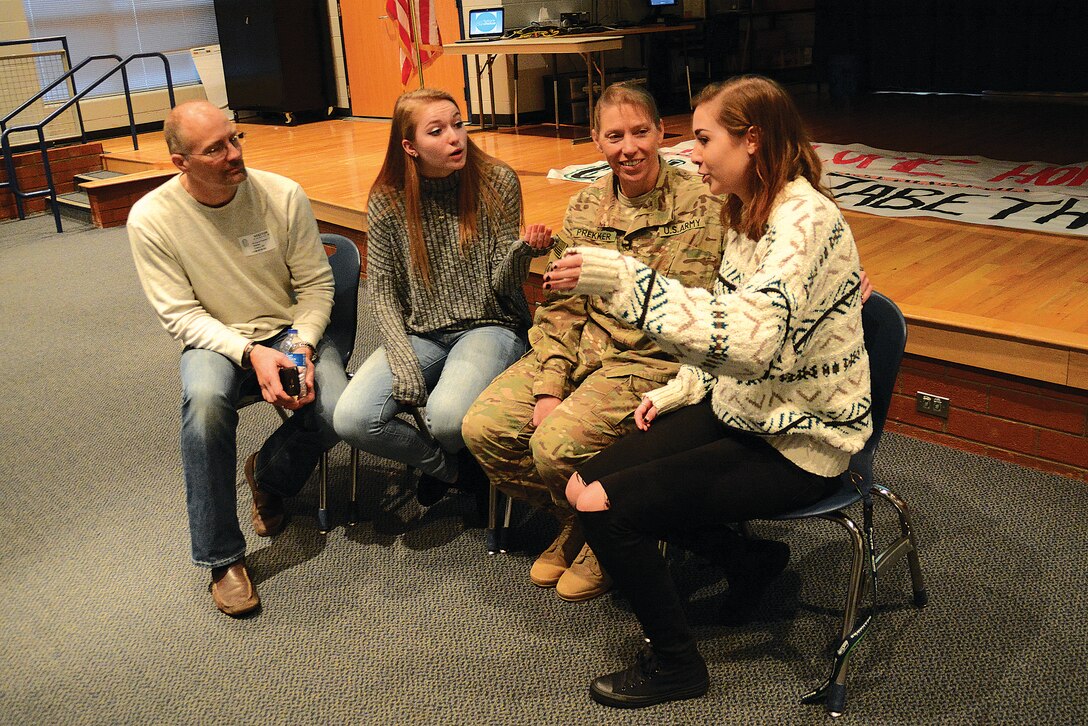 Army Col. Beth Prekker and her husband, Rick, talk with their daughters, Lindsay and Caroline, during their reunion at Cosby High School in Midlothian, Va., Jan. 5, 2017. Army photo by Lesley Atkinson