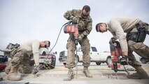 Tech. Sgt. Miguel Castano, 455th Expeditionary Civil Engineer Squadron structures shop NCO in-charge, Senior Airman Adam Parizo, 455th ECES power production specialist, and Airman 1st Class Abram Burkhart, 455th ECES Structures Specialist, repair a strip of runway Feb. 1, 2017 at Bagram Airfield, Afghanistan. The concrete suffered wear and tear from the constant aircraft traffic. (U.S. Air Force photo by Staff Sgt. Katherine Spessa)