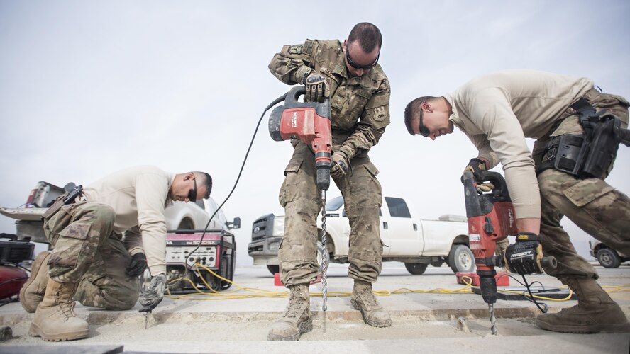 Tech. Sgt. Miguel Castano, 455th Expeditionary Civil Engineer Squadron structures shop NCO in-charge, Senior Airman Adam Parizo, 455th ECES power production specialist, and Airman 1st Class Abram Burkhart, 455th ECES Structures Specialist, repair a strip of runway Feb. 1, 2017 at Bagram Airfield, Afghanistan. The concrete suffered wear and tear from the constant aircraft traffic. (U.S. Air Force photo by Staff Sgt. Katherine Spessa)