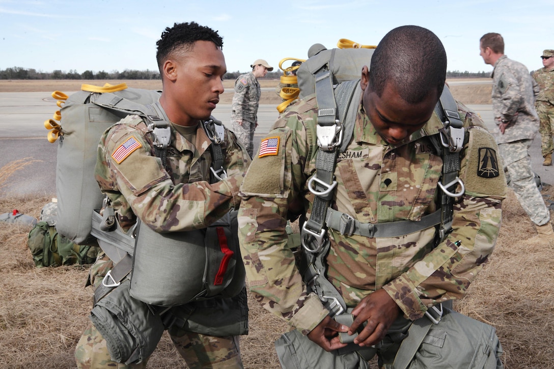 Army Spcs. Torrance Saunders, left, and Marcus Gresham put on their T-11 parachutes during Operation Anvil paratrooper refresher training at Fort Jackson, S.C., Jan. 26, 2017. Saunders and Gresham are assigned to the 982nd Combat Camera (Airborne). Army photo by Spc. Christopher Martin