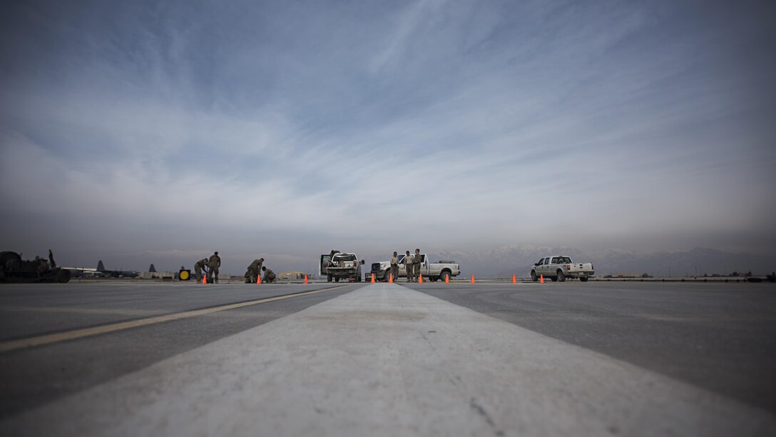 Members of the 455th Expeditionary Civil Engineer Squadron repair a strip of runway Feb. 1 2017 at Bagram Airfield, Afghanistan. The 455th ECES Pavements and Construction; Power Productions; and Structures Shops teamed up to repair a strip of damaged runway. (U.S. Air Force photo by Staff Sgt. Katherine Spessa)