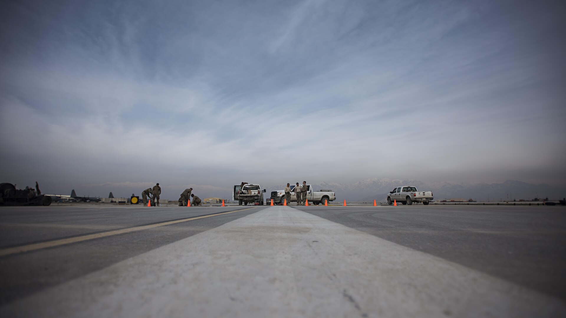 Members of the 455th Expeditionary Civil Engineer Squadron repair a strip of runway Feb. 1 2017 at Bagram Airfield, Afghanistan. The 455th ECES Pavements and Construction; Power Productions; and Structures Shops teamed up to repair a strip of damaged runway. (U.S. Air Force photo by Staff Sgt. Katherine Spessa)