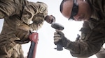 Senior Airmen Matthew Chapman and Adam Parizo, 455th Expeditionary Civil Engineer Squadron Power Productions specialists, repair a strip of runway Feb. 1, 2017 at Bagram Airfield, Afghanistan. Three different career fields worked together for the complex repair job. (U.S. Air Force photo by Staff Sgt. Katherine Spessa)