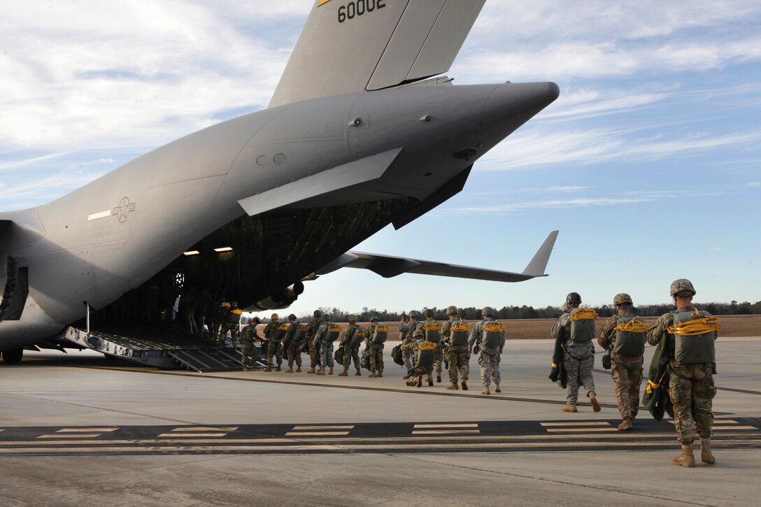 Paratroopers prepare to board an Air Force C-17 Globemaster aircraft for a mass tactical airborne jump during Operation Anvil paratrooper refresher training at North Air Force Auxiliary Base, S.C., Jan. 26, 2017. Paratroopers assigned to the 360th Civil Affairs Brigade. Army photo by Spc. Christopher Martin