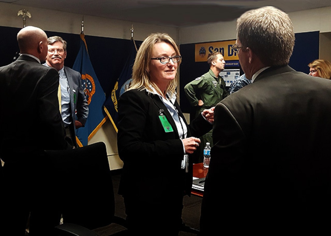 Defense Logistics Agency Aviation's Acquisition Executive Cathy Contreras speaks with Northrup Grumman representatives on the support for the E-2C Hawkeye and the C-2A Greyhound aircrafts' landing gear material, Jan. 26, 2017, at the Fleet Readiness Center Southwest, on Naval Air Station, North Island, California.