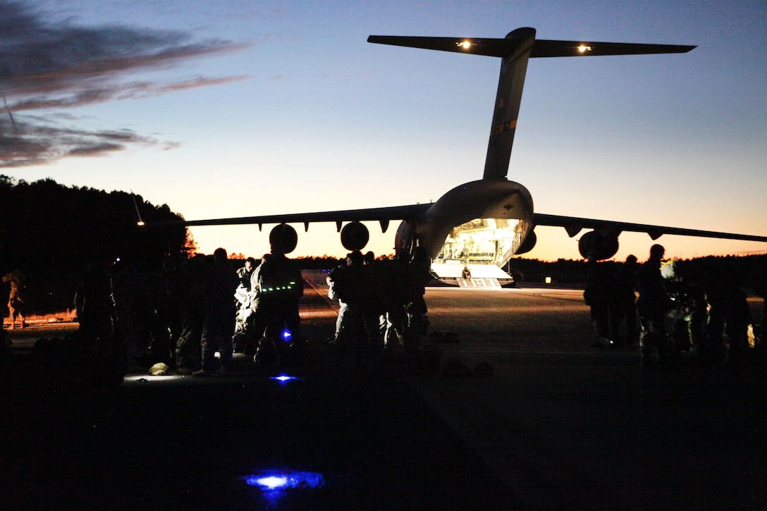 Paratroopers prepare to board an Air Force C-17 Globemaster aircraft for a night mass tactical airborne jump during Operation Anvil refresher training at North Air Force Auxiliary Base, S.C., Jan. 26, 2017. The paratroopers are assigned to the 360th Civil Affairs Brigade. Army photo by Spc. Christopher Martin